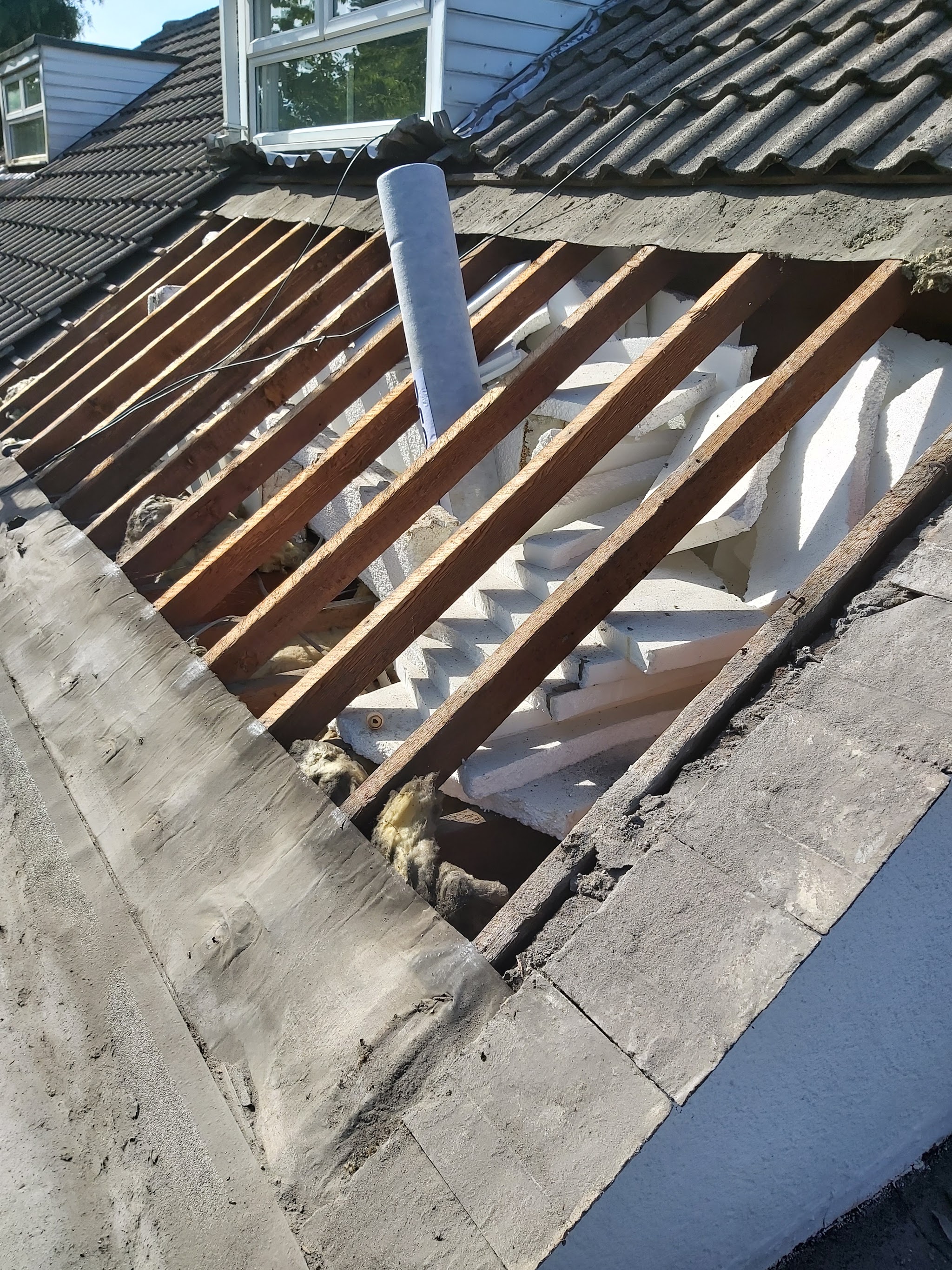 An old roof stripped back to bare rafters by M.D Roofing