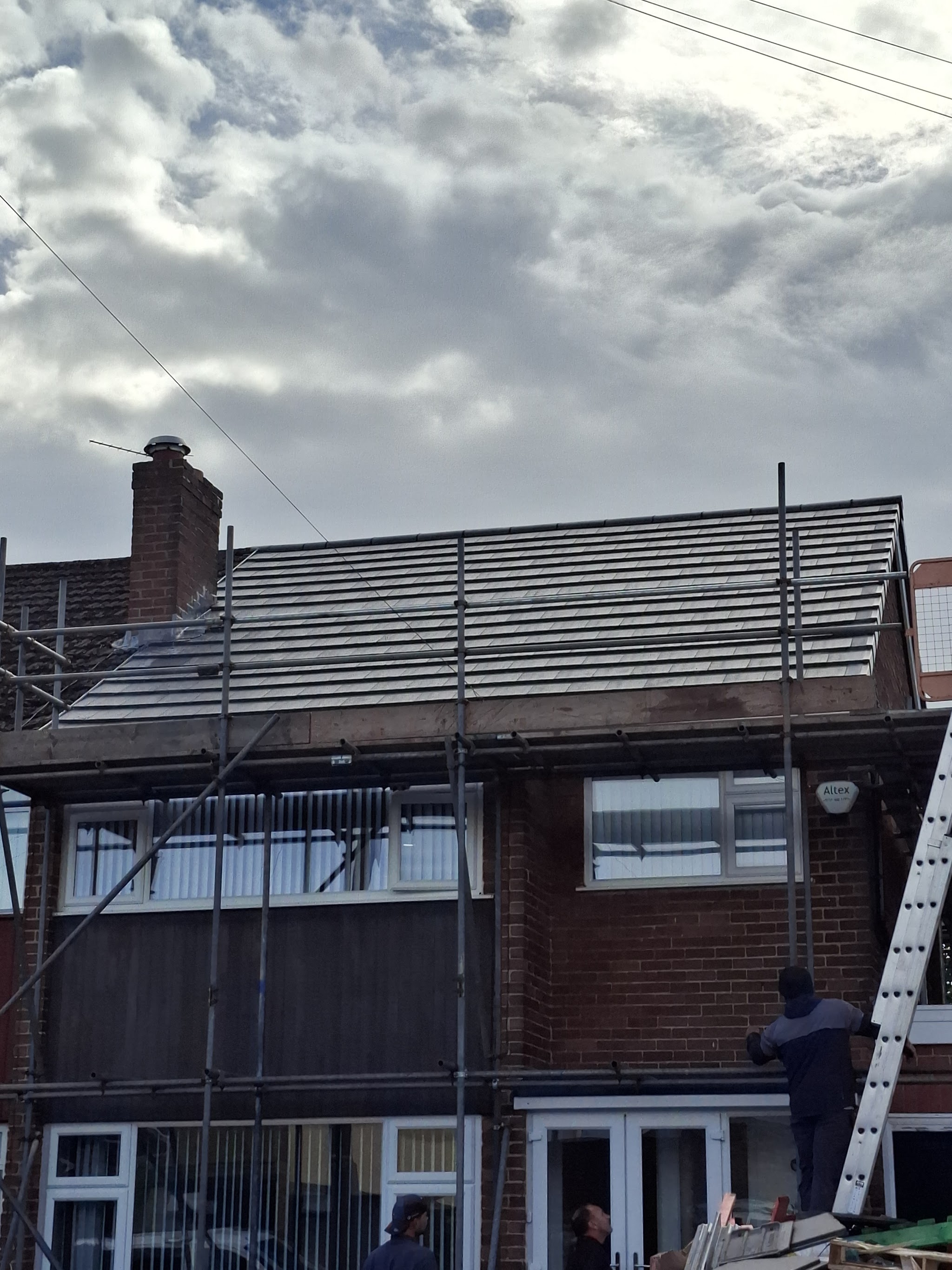 A house under scaffold with a newly tiled roof