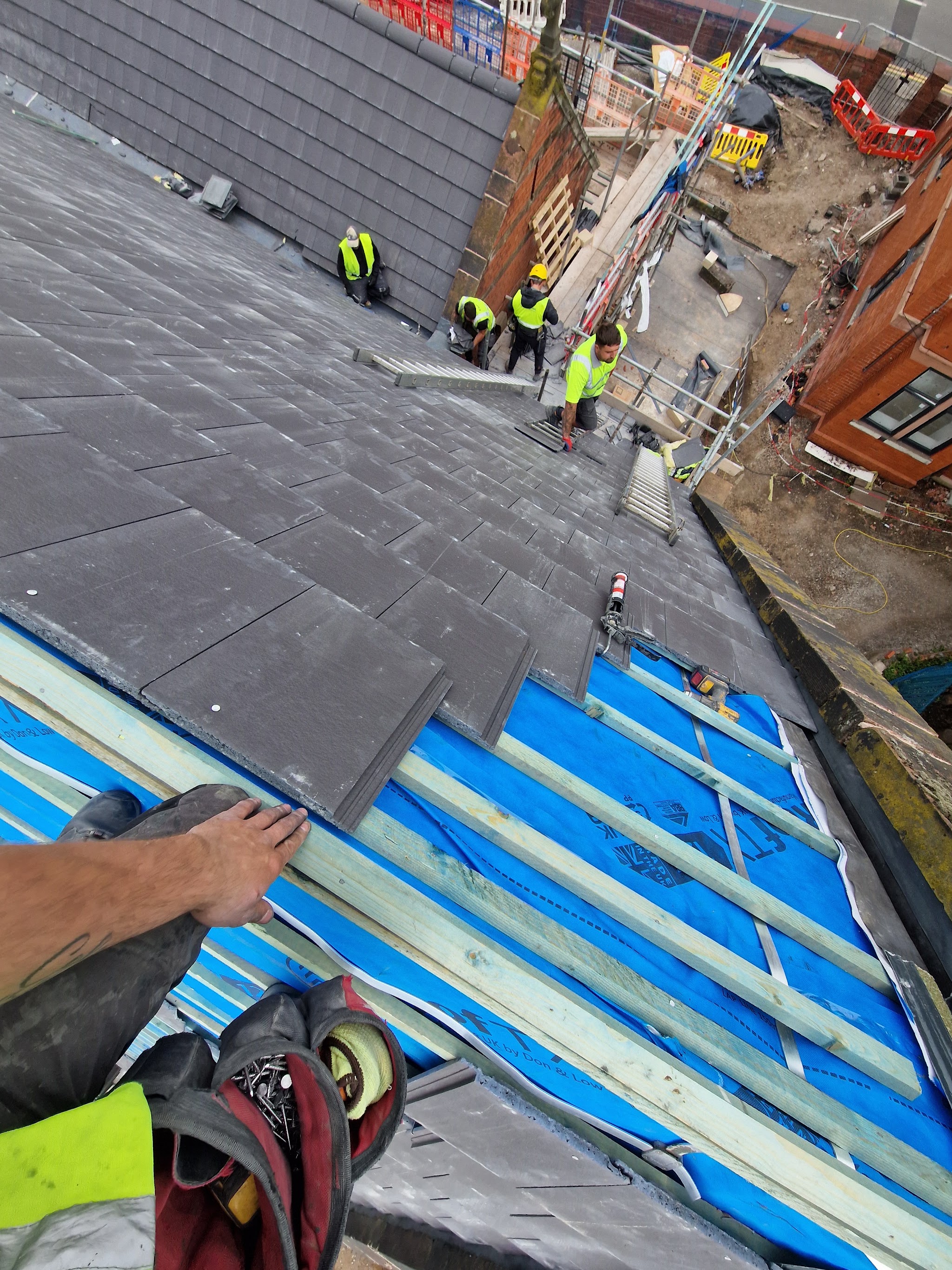 Roofers laying slates on a new-build site